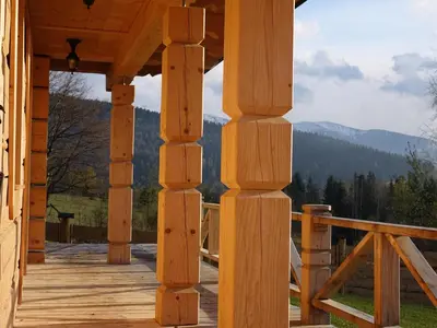 a wooden porch with a view of the mountains at Domki Zawoja z Jacuzzi in Zawoja