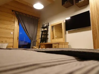 a bedroom with a bed with a mirror and a tv at Domki Zawoja z Jacuzzi in Zawoja