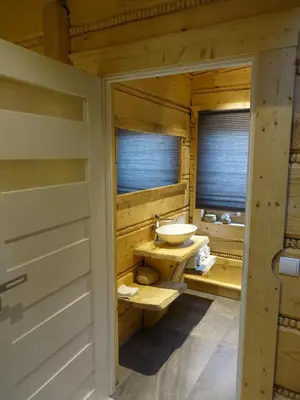 a bathroom with a sink in a wooden house at Domki Zawoja z Jacuzzi in Zawoja