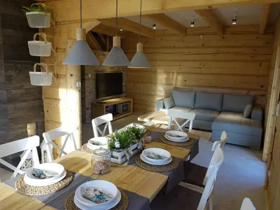 a living room with a table and a couch at Domki Zawoja z Jacuzzi in Zawoja