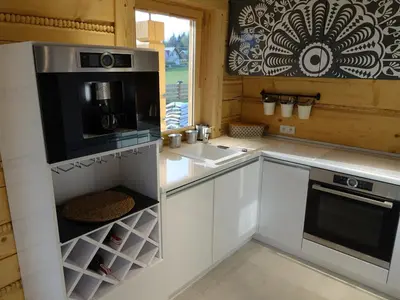 a kitchen with white cabinets and a microwave at Domki Zawoja z Jacuzzi in Zawoja
