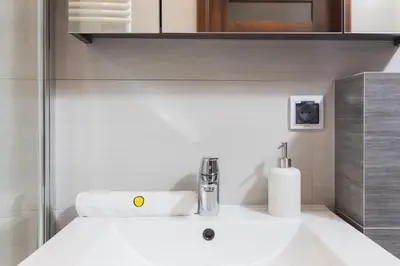a bathroom with a sink with a soap dispenser on it at InPoint One Bedroom Apartment with Balcony Self Check-In near Vistula River&Tauron Arena in Kraków