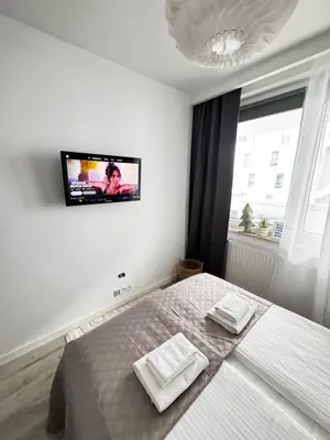 a bedroom with a bed and a tv on the wall at InPoint One Bedroom Apartment with Balcony Self Check-In near Vistula River&Tauron Arena in Kraków