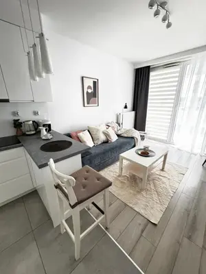 a kitchen and living room with a couch and a table at InPoint One Bedroom Apartment with Balcony Self Check-In near Vistula River&Tauron Arena in Kraków