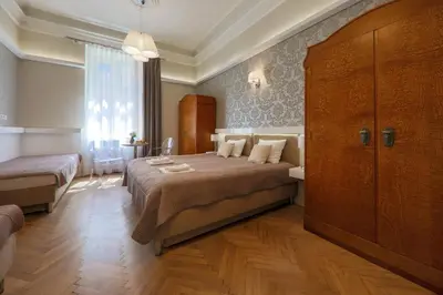 a bedroom with a large bed and a large window at Apartamenty Podwale in Kraków