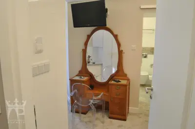 a bathroom with a vanity with a mirror and a tv at Apartamenty Podwale in Kraków
