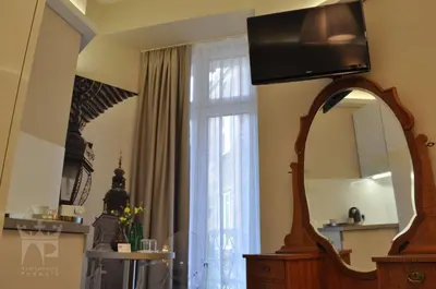a living room with a mirror and a window at Apartamenty Podwale in Kraków