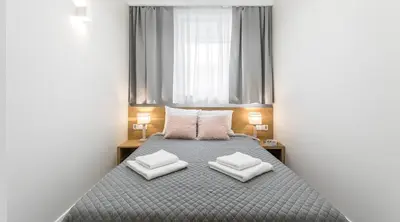 a bedroom with a bed with two pillows on it at Ariańska Apartment - lift & AC in Kraków
