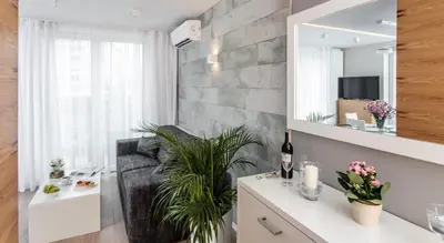a living room with a couch and a mirror at Ariańska Apartment - lift & AC in Kraków