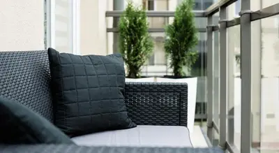 a black pillow sitting on a chair on a balcony at Ariańska Apartment - lift & AC in Kraków