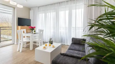 a living room with a couch and a table at Ariańska Apartment - lift & AC in Kraków
