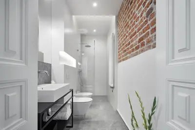 a bathroom with a sink toilet and a brick wall at St Agnes Apartments Old Town in Kraków