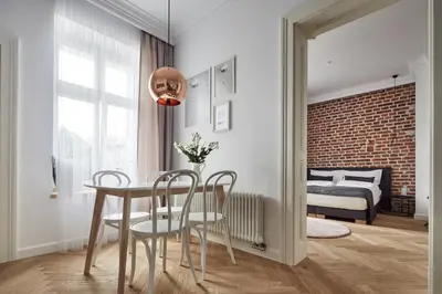 a dining room with a table and chairs and a bedroom at St Agnes Apartments Old Town in Kraków