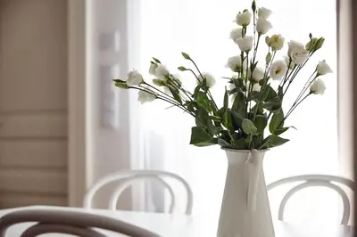 a white vase with white flowers sitting on a table at St Agnes Apartments Old Town in Kraków