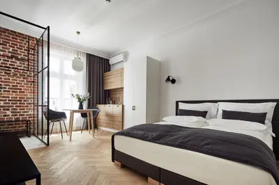 a bedroom with a large bed and a brick wall at St Agnes Apartments Old Town in Kraków