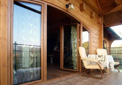 a screened in porch with two chairs and a sliding glass door at Chata wsród Malw in Wilkowisko