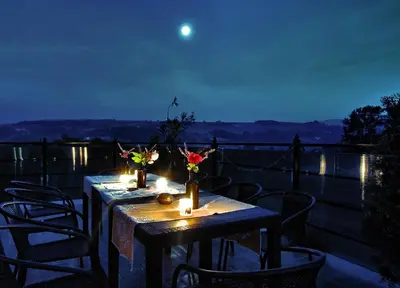 two tables with candles and flowers on a balcony at night at Chata wsród Malw in Wilkowisko