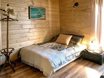 a bedroom with a bed in a wooden wall at Chata wsród Malw in Wilkowisko