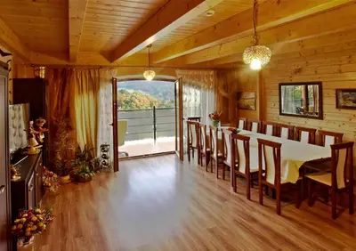 a dining room with a table and chairs and a balcony at Chata wsród Malw in Wilkowisko