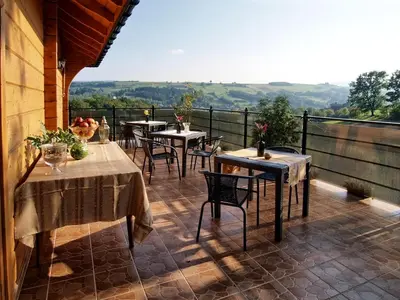 a patio with tables and chairs on a balcony at Chata wsród Malw in Wilkowisko