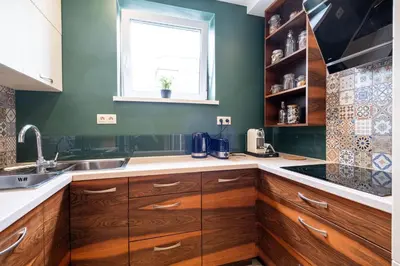 a kitchen with wooden cabinets and a window at Stawowa Premium Apartment - 69 m2 with sauna and private garage in Kraków