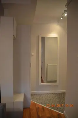 a hallway with a mirror in a white room at Cichy apartament w centrum Krakowa Salwator in Kraków