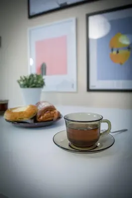 a cup of coffee and a plate of donuts on a counter at LION apartments - Your own apartment in Cracow in Kraków