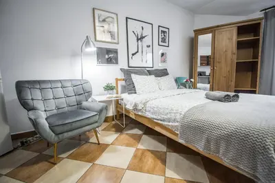 a bedroom with a bed and a chair at LION apartments - Your own apartment in Cracow in Kraków