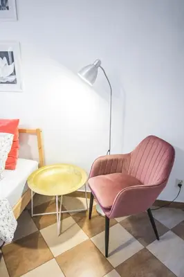 a living room with a pink chair and a table at LION apartments - Your own apartment in Cracow in Kraków