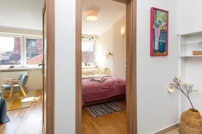 a mirror in a room with a bed and a kitchen at Blue Sky Apartment in Kraków