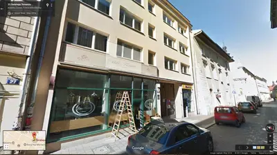 a building on a street with a car parked in front at Blue Sky Apartment in Kraków