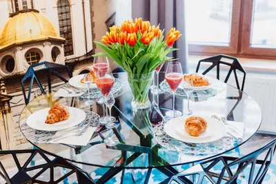 a glass table with plates of pastries and wine glasses at Z14 Boutique Residence - Krakow Old Town in Kraków