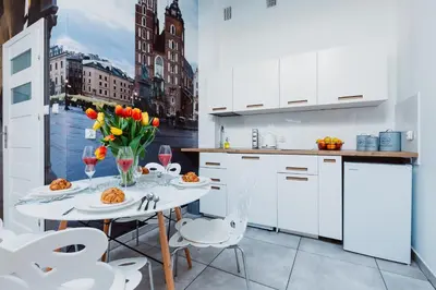 a white kitchen with a table with flowers on it at Z14 Boutique Residence - Krakow Old Town in Kraków