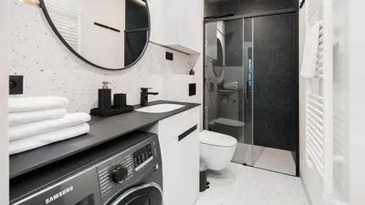 a bathroom with a washer and dryer and a mirror at Premium in Novum City Center, Sun & Snow in Kraków