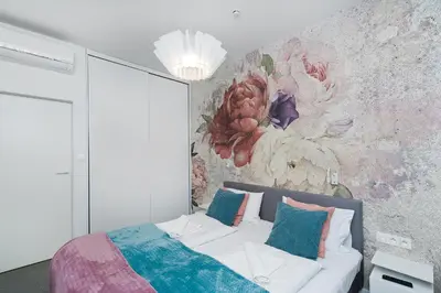 a bedroom with a bed with a flower mural on the wall at Premium in Novum City Center, Sun & Snow in Kraków