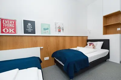 a bedroom with two beds and posters on the wall at Premium in Novum City Center, Sun & Snow in Kraków