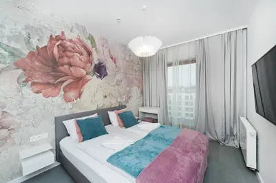 a bedroom with a bed with a flower mural on the wall at Premium in Novum City Center, Sun & Snow in Kraków