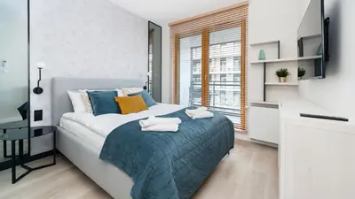 a bedroom with a bed with a blue blanket at Premium in Novum City Center, Sun & Snow in Kraków