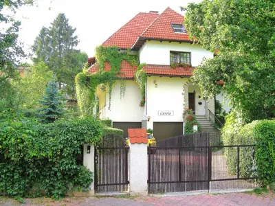 a white house with a gate with ivy on it at VILLA CASSIA przy Parku Zdrojowym in Rabka