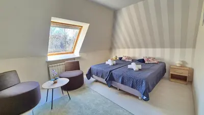 a bedroom with two beds and a chair and a window at VILLA CASSIA przy Parku Zdrojowym in Rabka