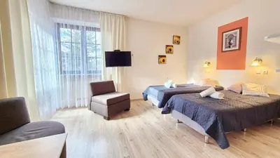 a hotel room with two beds and a chair at VILLA CASSIA przy Parku Zdrojowym in Rabka