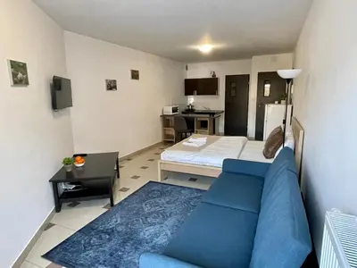 a living room with a blue couch and a kitchen at Bubble Apartments in Kraków
