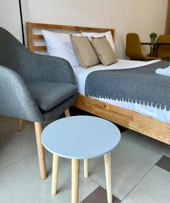 a bedroom with a bed and a chair and a table at Bubble Apartments in Kraków