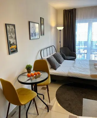 a living room with a bed and a table and chairs at Bubble Apartments in Kraków