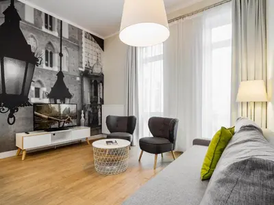 a living room with a couch and a tv at Riverside Aparthotel Cracow in Kraków