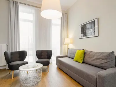 a living room with a couch and two chairs at Riverside Aparthotel Cracow in Kraków
