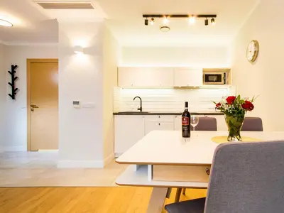 a kitchen with a table with a bottle of wine at Riverside Aparthotel Cracow in Kraków