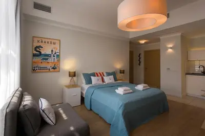 a bedroom with a bed and a couch in it at Riverside Aparthotel Cracow in Kraków