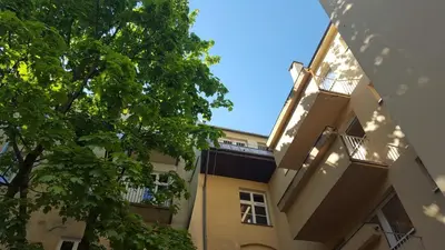 a building with a tree in front of it at Apartment Katamaran in Kraków