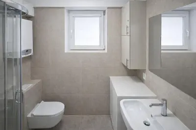 a white bathroom with a toilet and a sink at Apartment Katamaran in Kraków